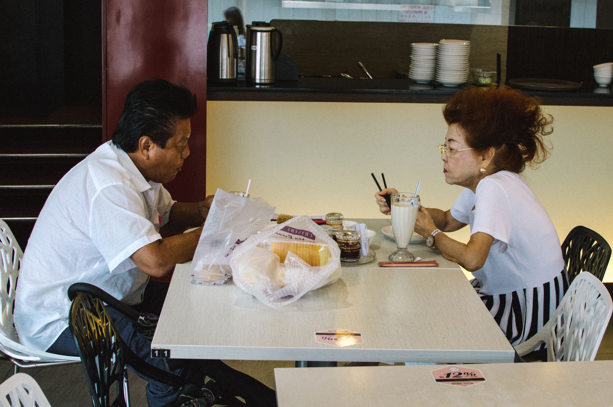 Two people eating at food court