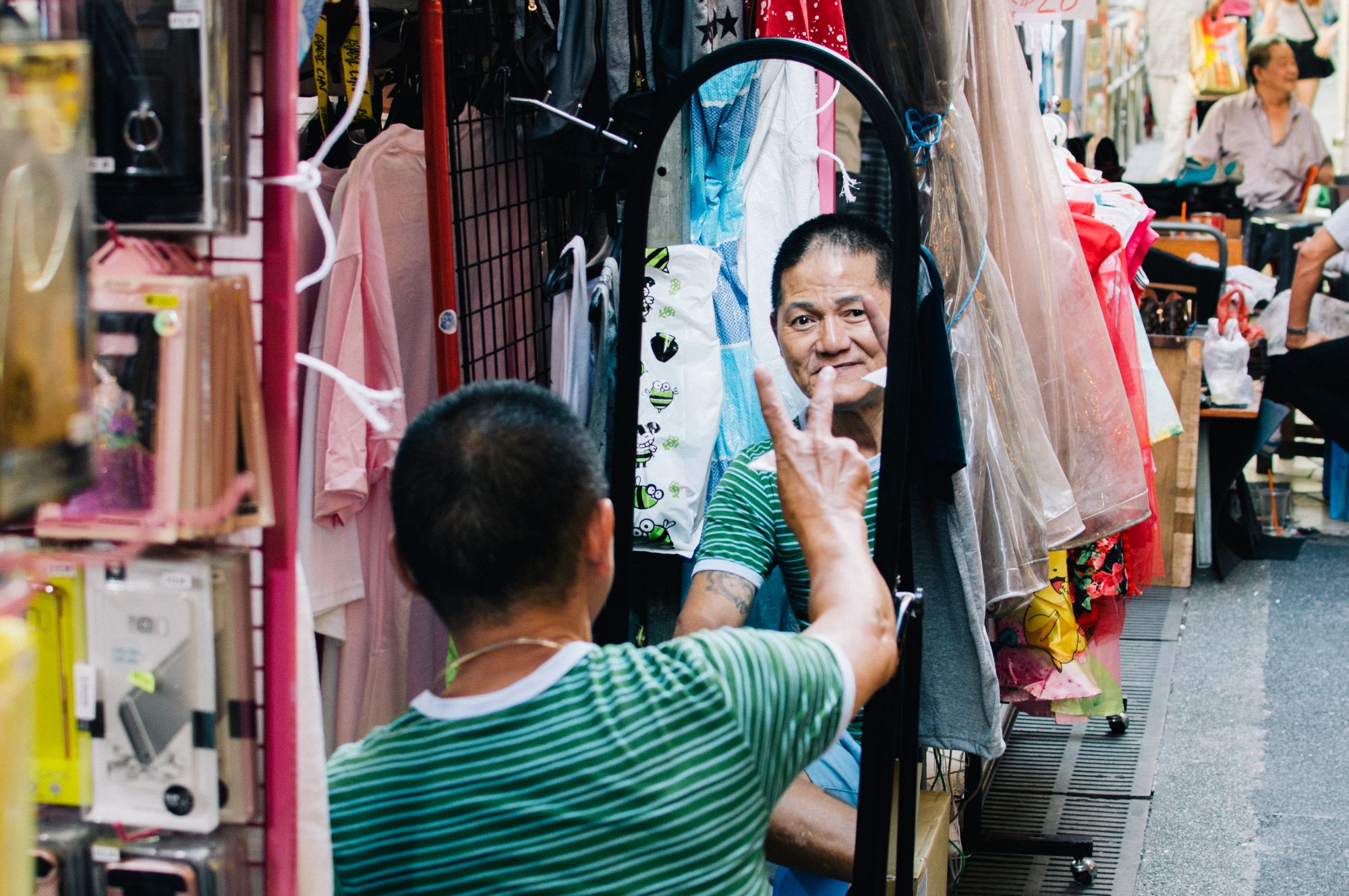 Man doing peace sign in mirror at market