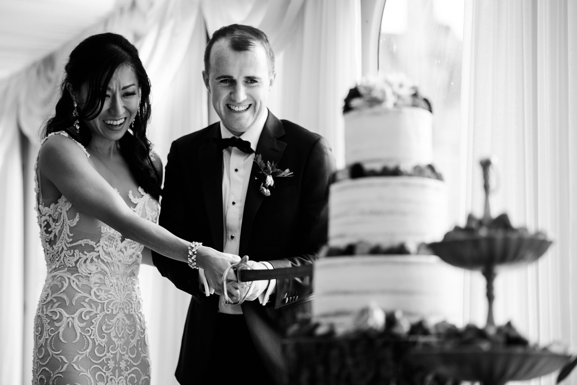 Newlyweds cut wedding cake together with sword