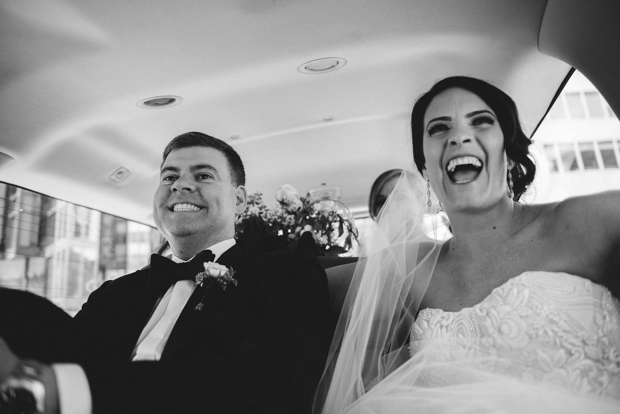 Bride and man smiling in car