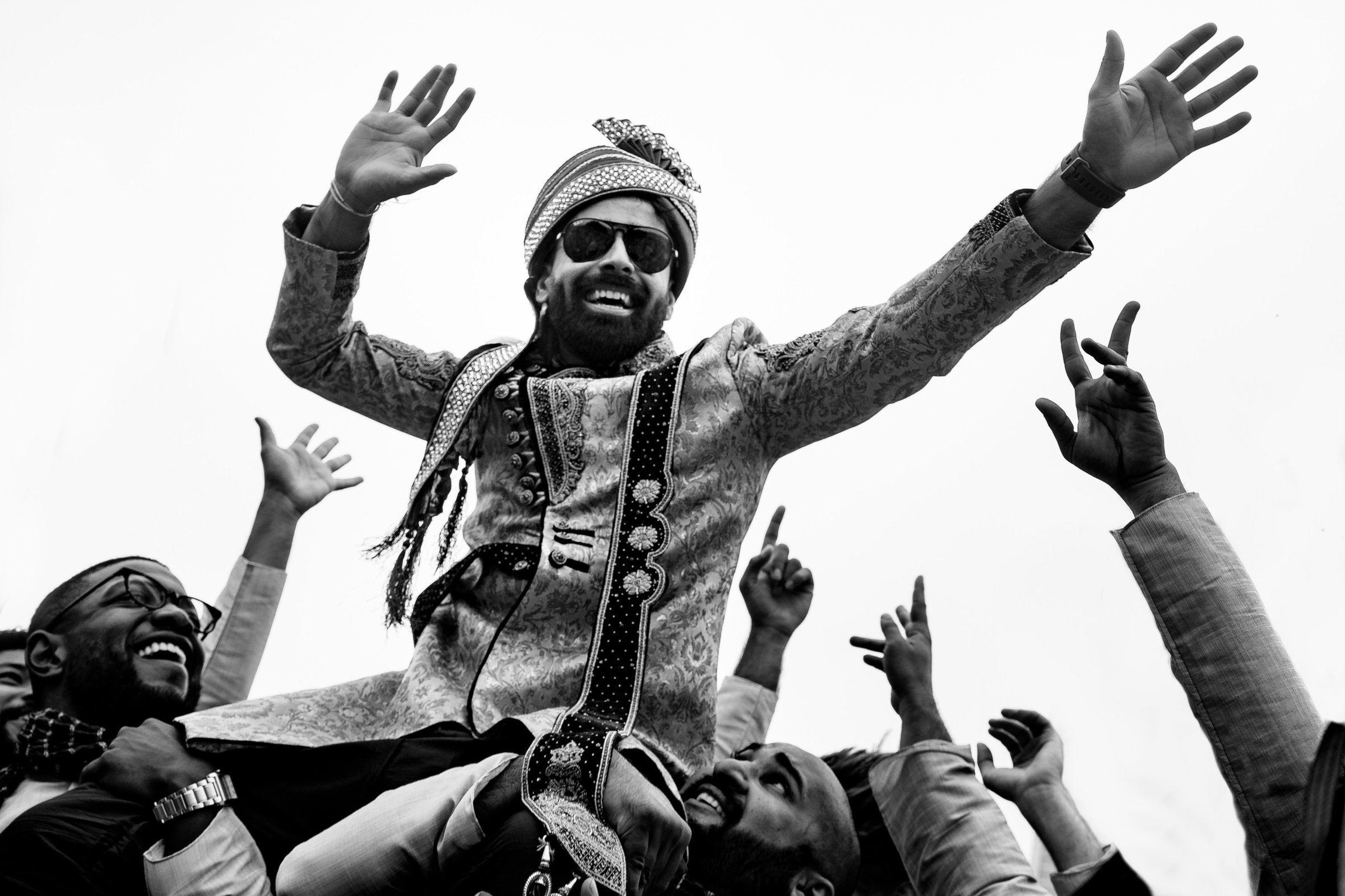 Overjoyed groom on the shoulders of his guests
