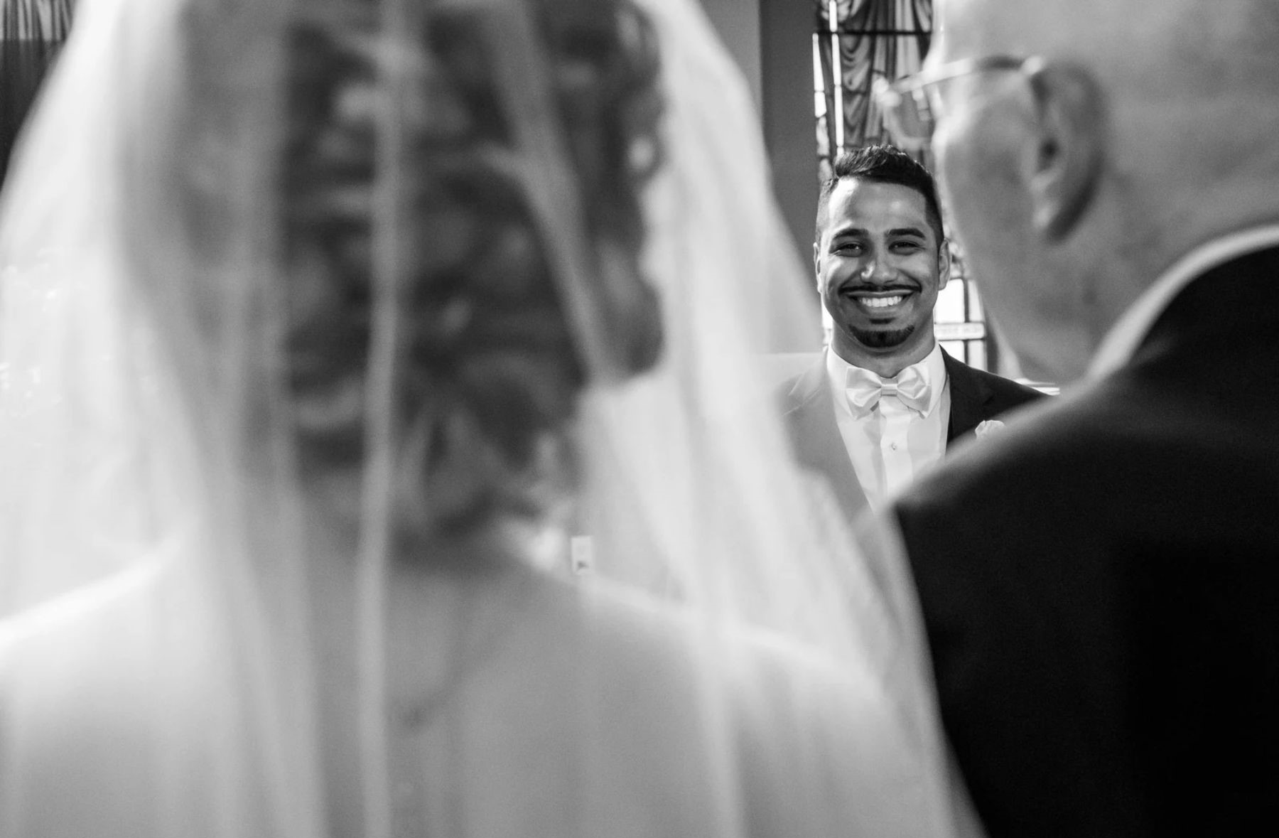 Groom looking at bride at altar