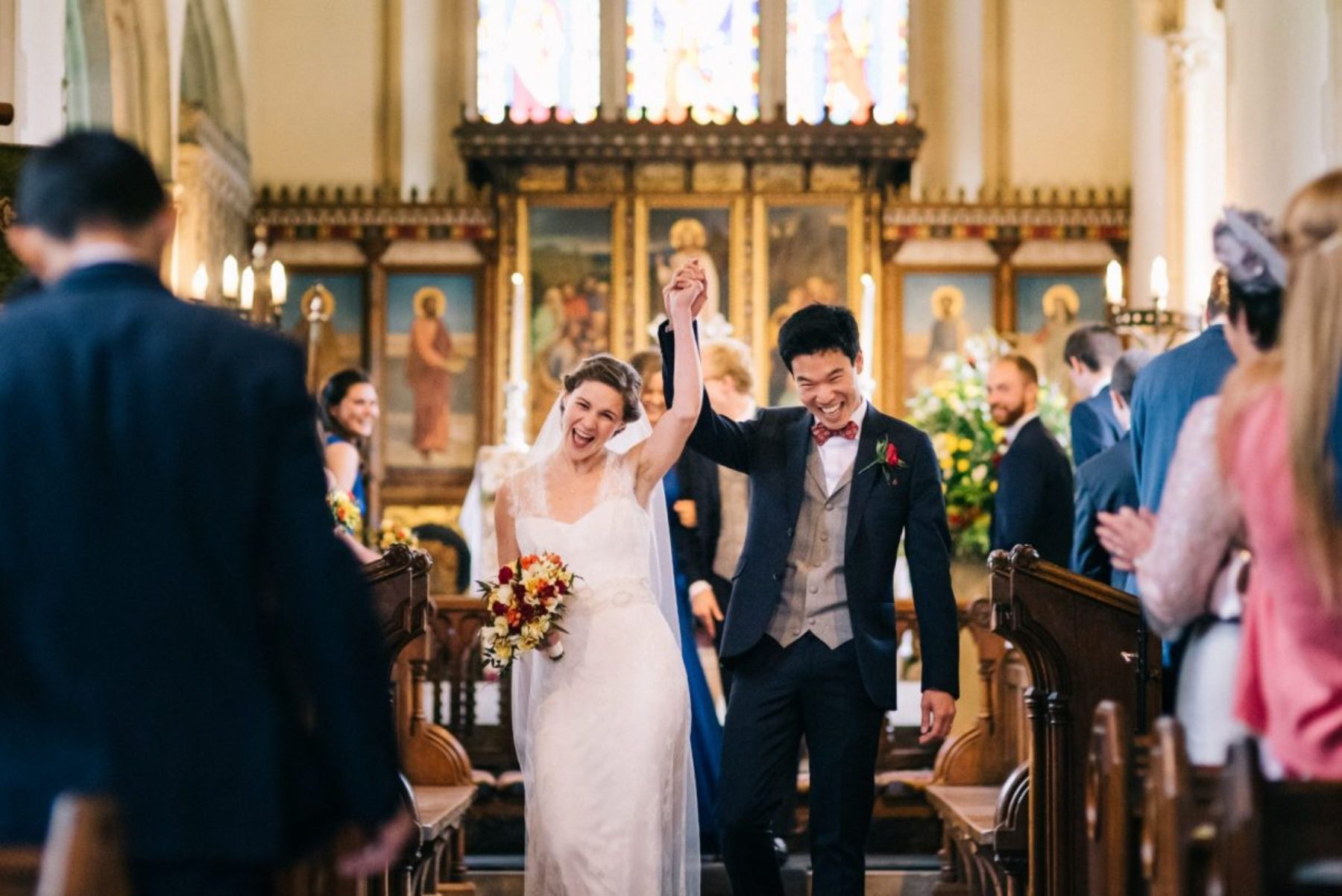 Overjoyed newlyweds smiling arms raised