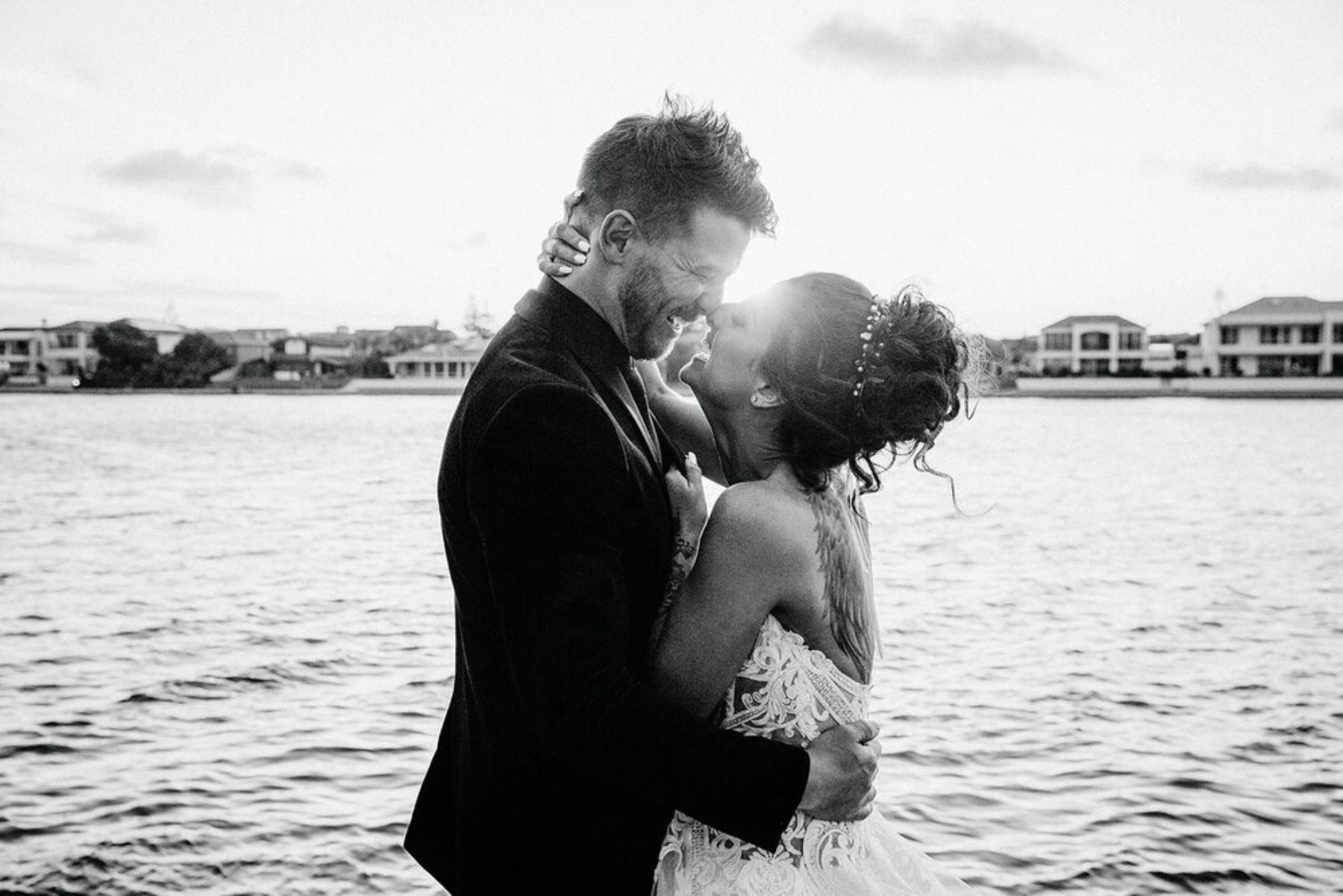 Bride and groom kiss by the sea