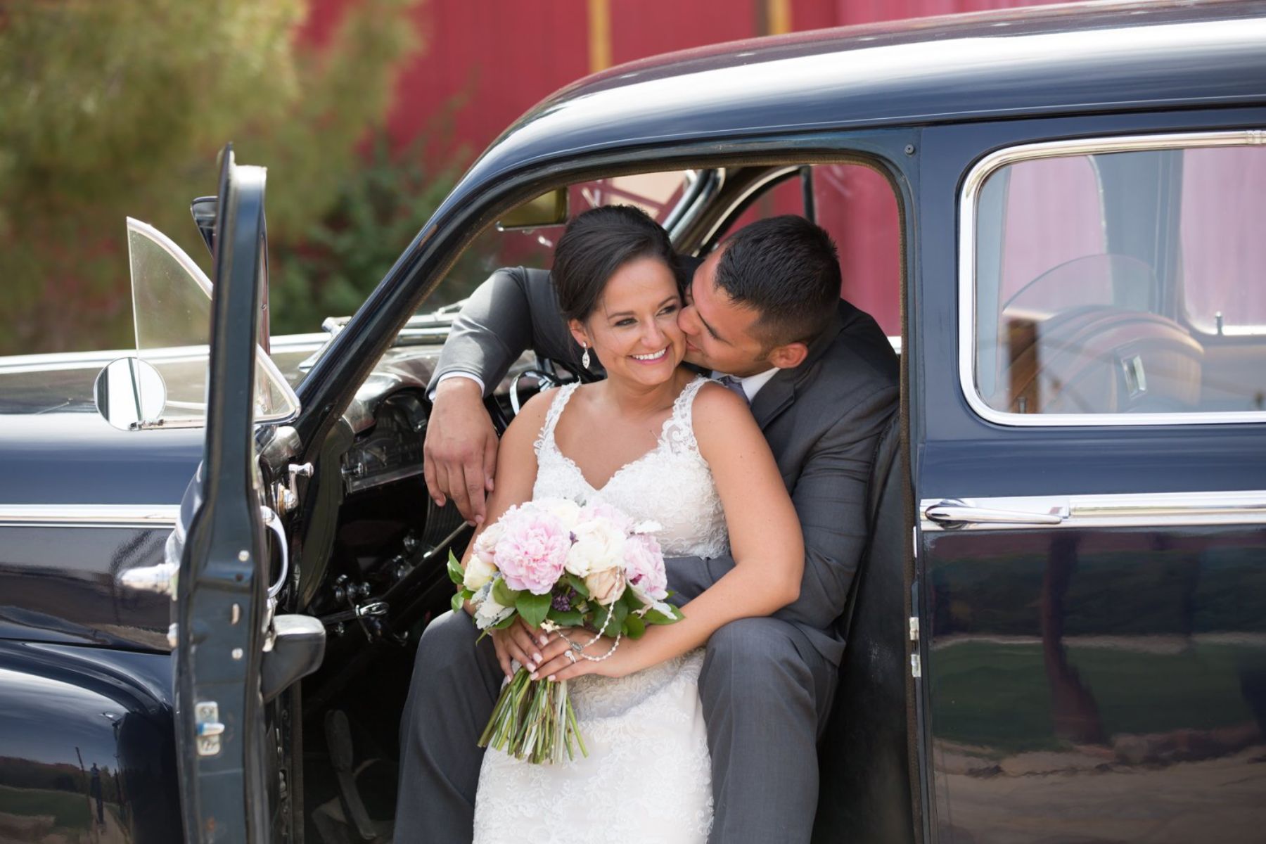 Newlyweds smiling together in car