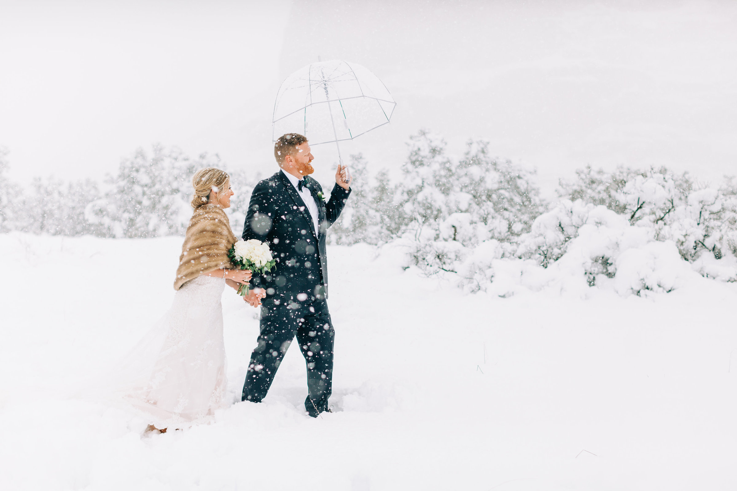 Bride and groom walking through the snow together
