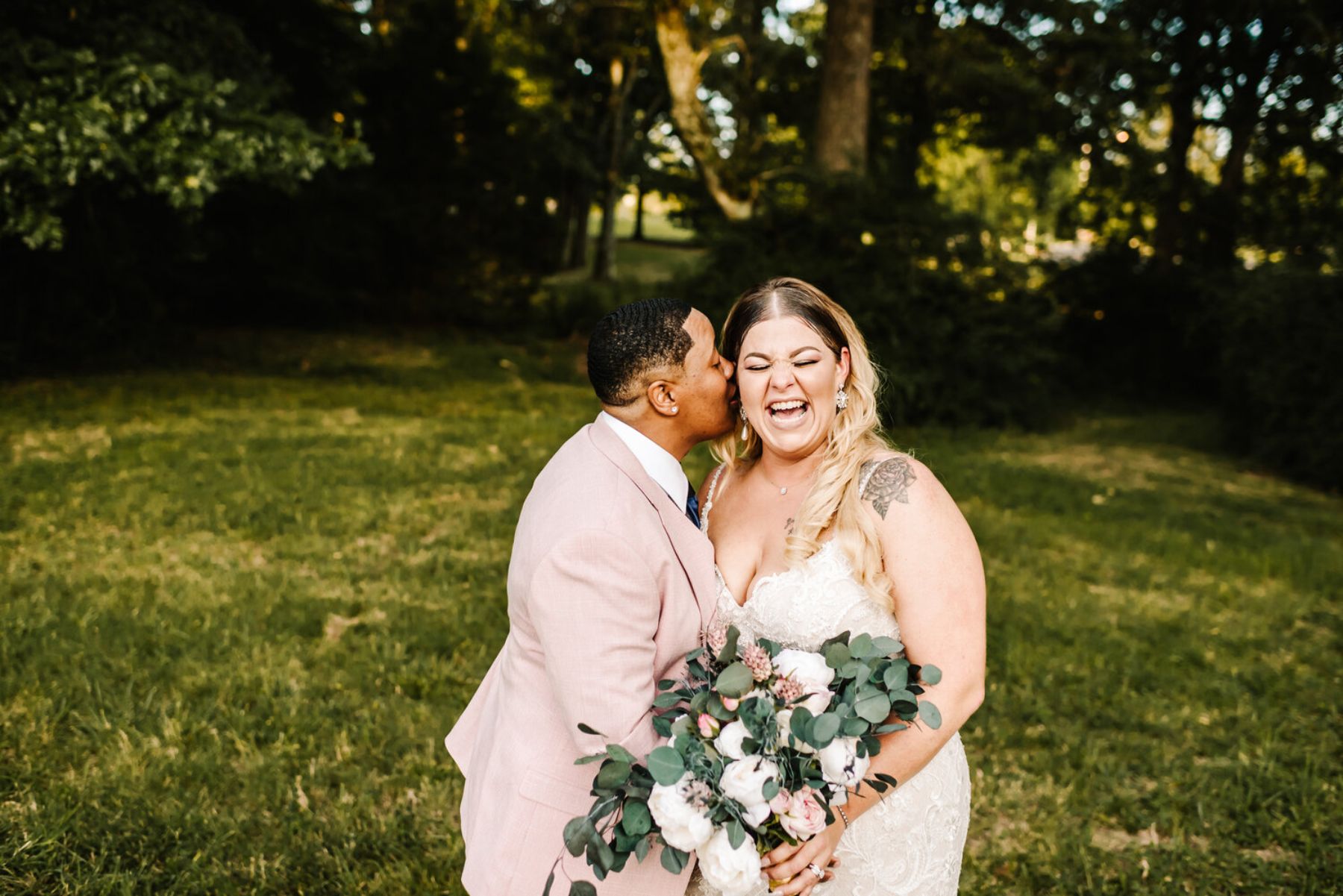 Newlyweds laughing in field