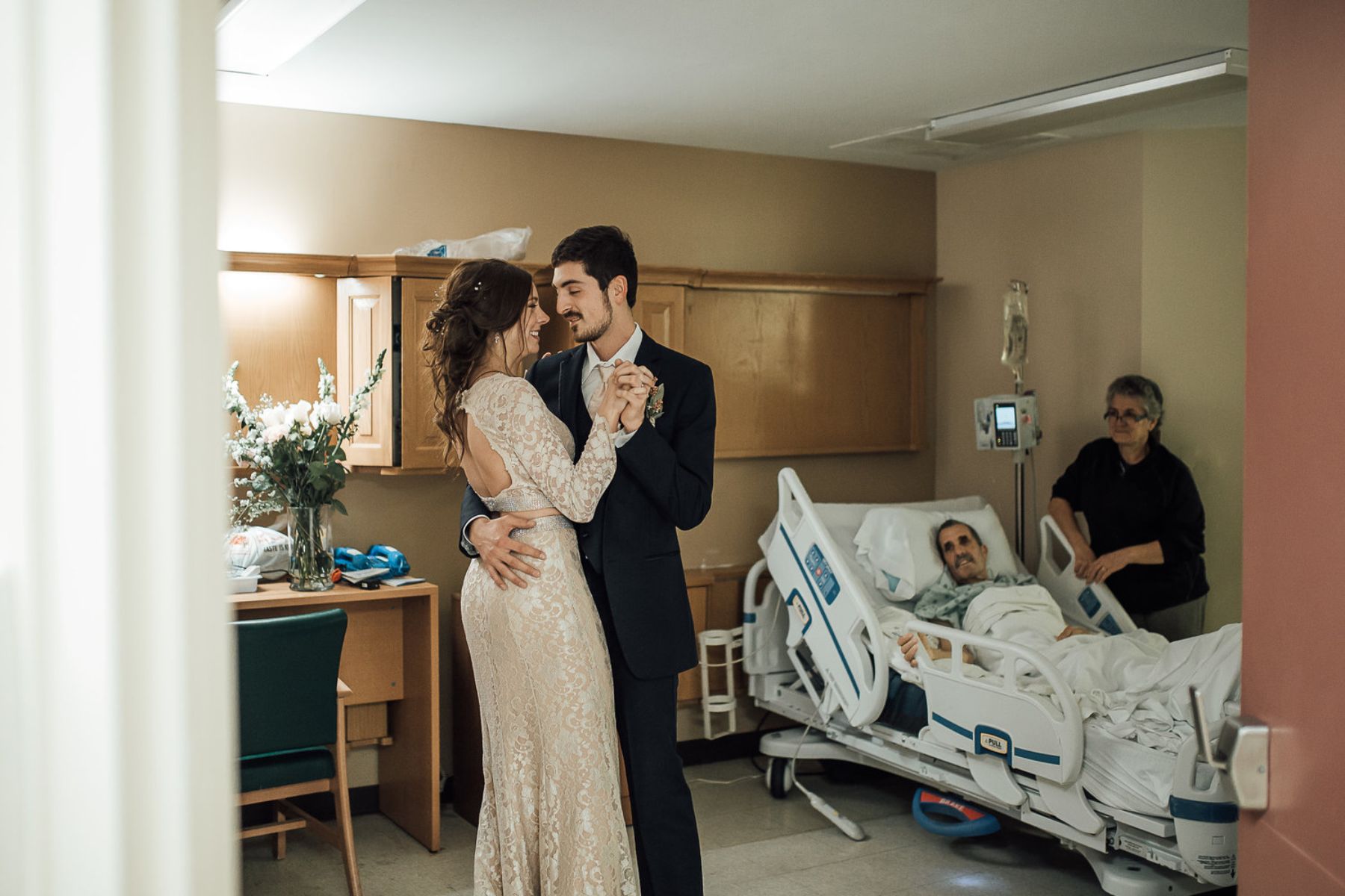 Couple dancing in hospital room while man and woman look on
