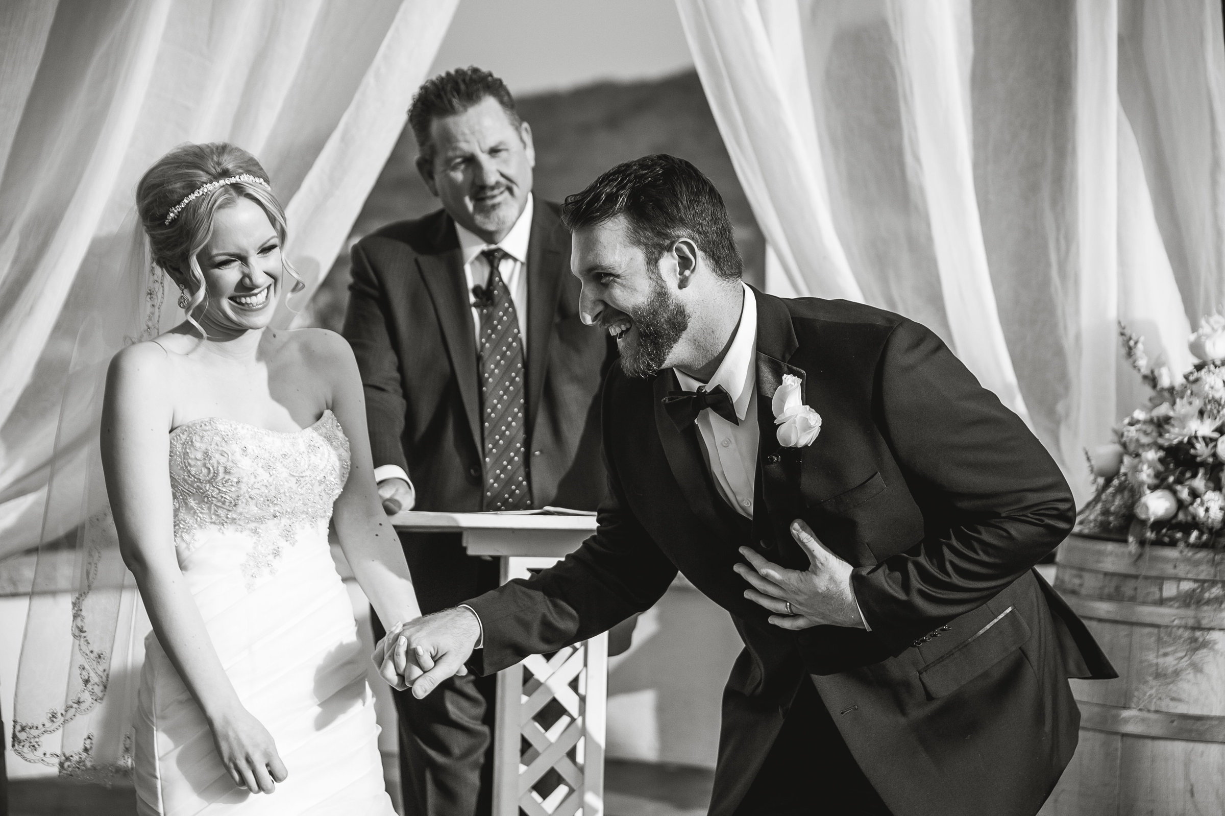 Bride and groom laughing at altar