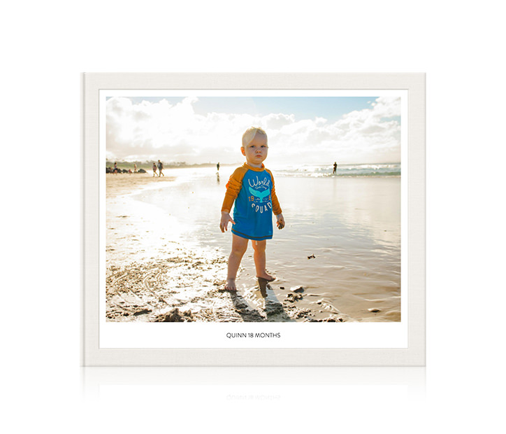 Fotolibro con un niño en la playa en la cubierta.