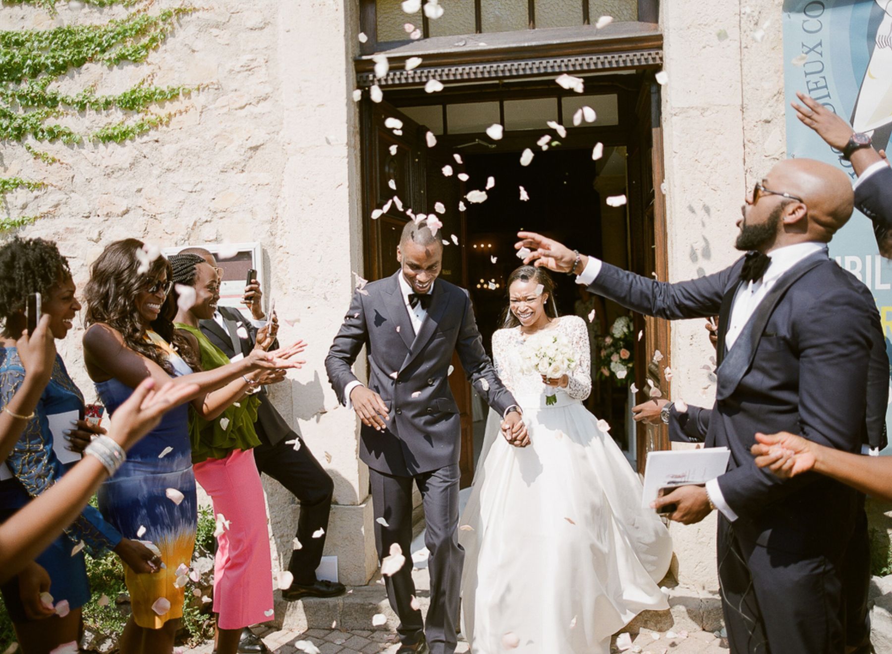 Bride and groom leaving the ceremony while guest throw rose petals