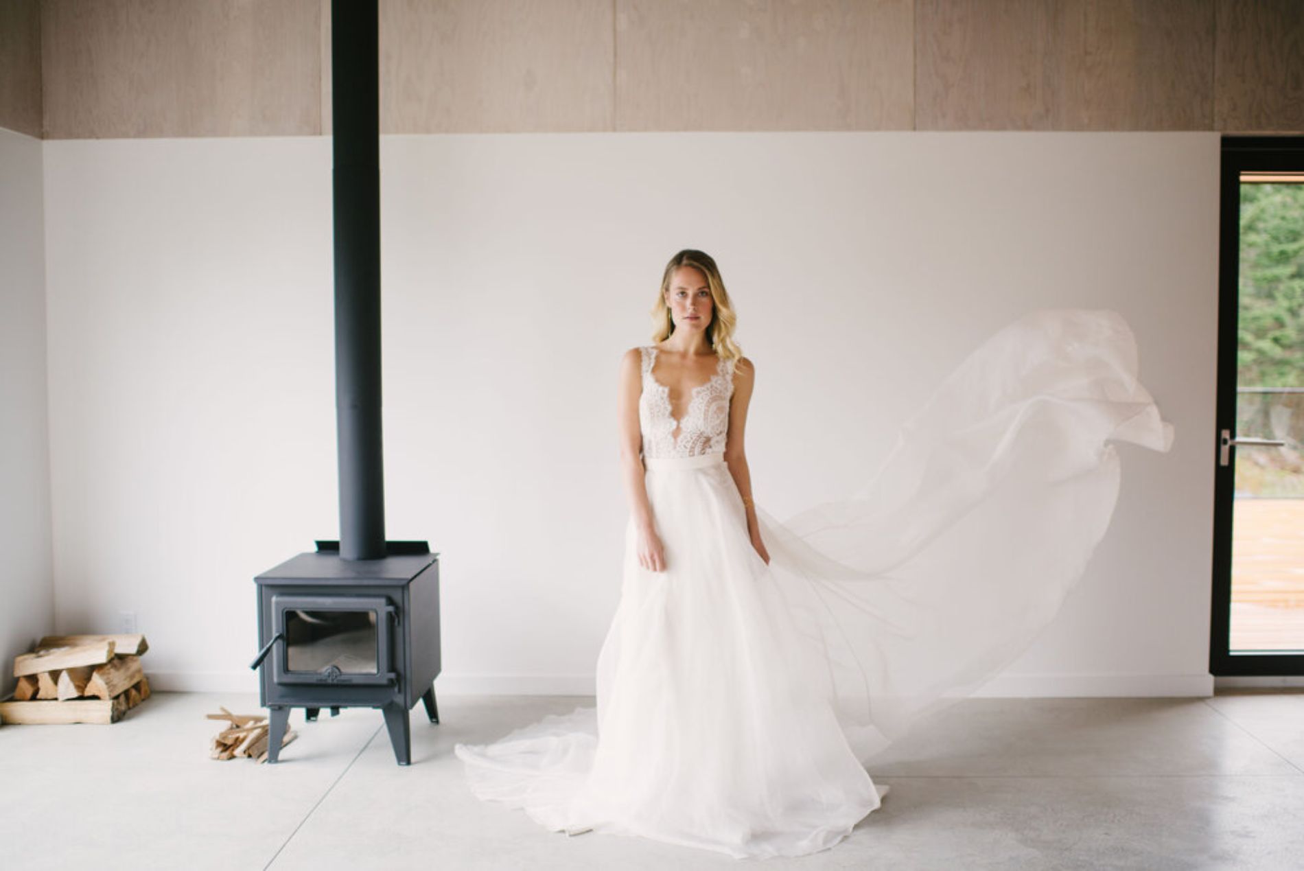 Woman in wedding dress posing by fireplace