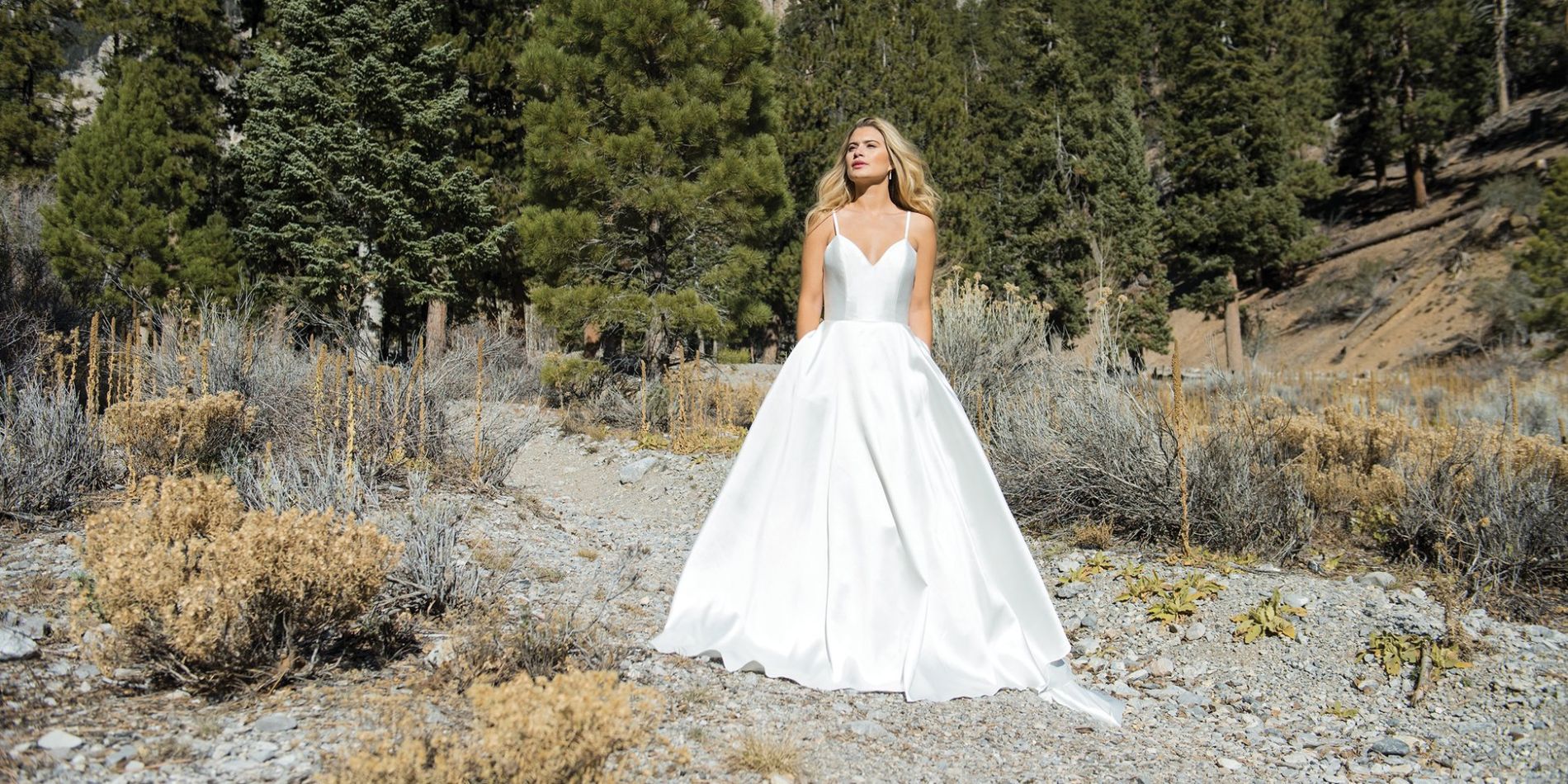 Woman modelling wedding dress in rocky landscape