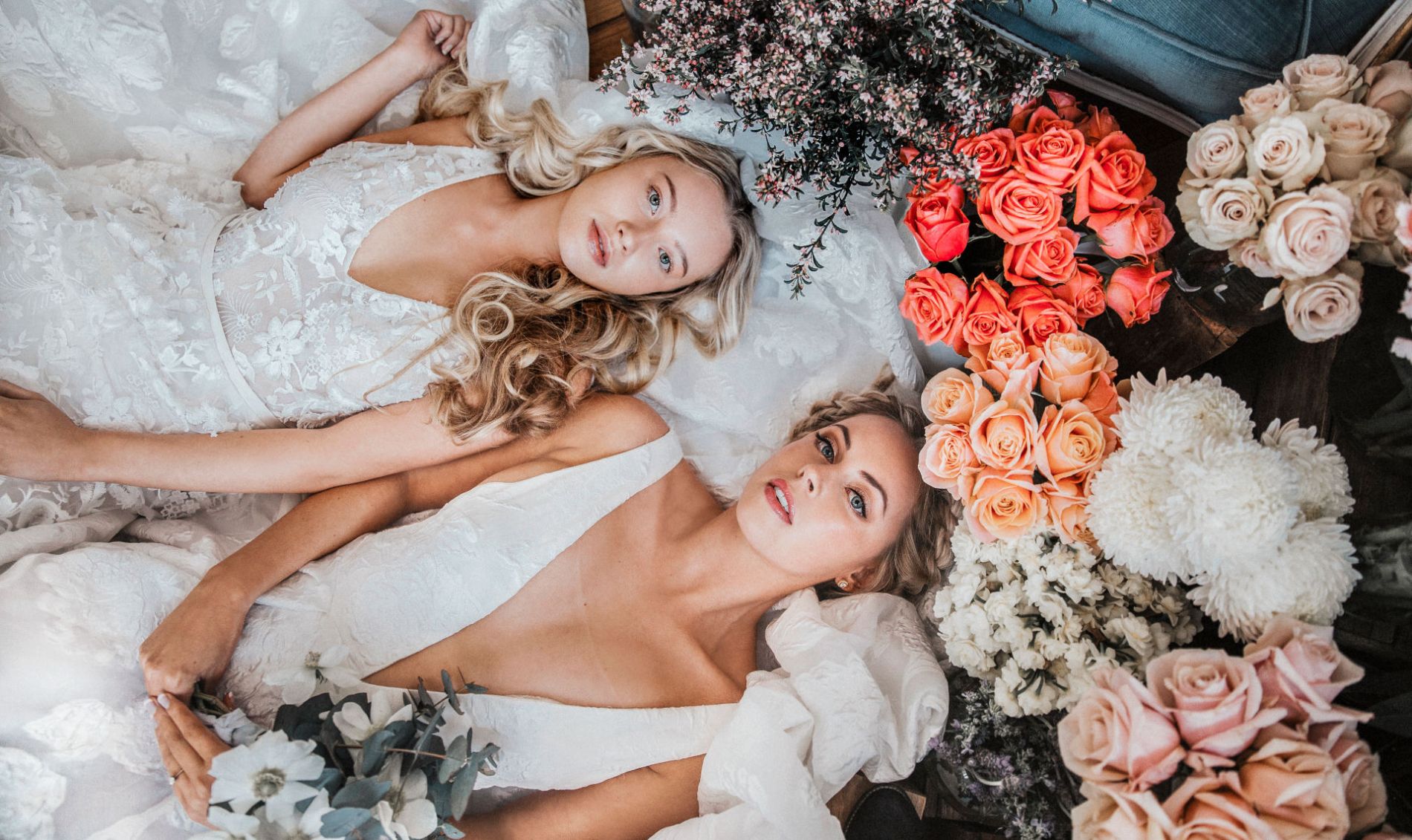 Brides lying amongst roses and flowers