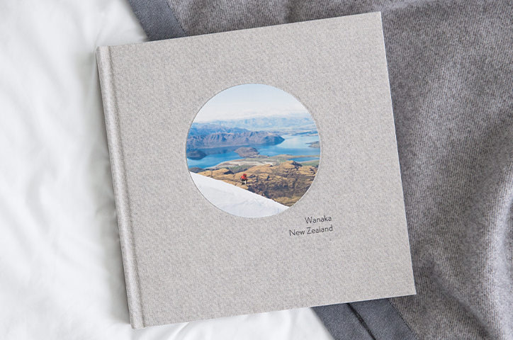 Photo book with cover of mountains lying on bed