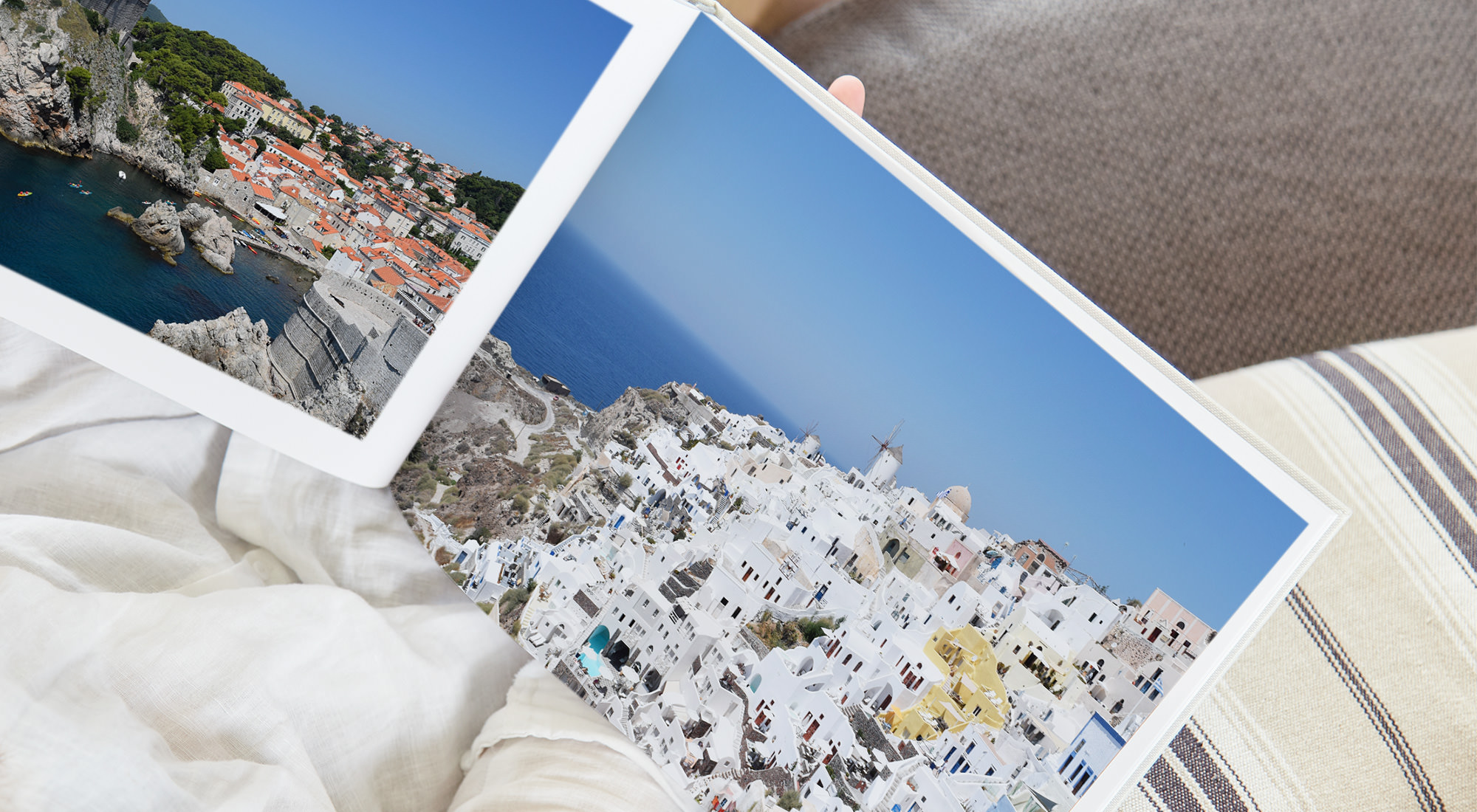 Open photo book with images of Santorini, Greece.