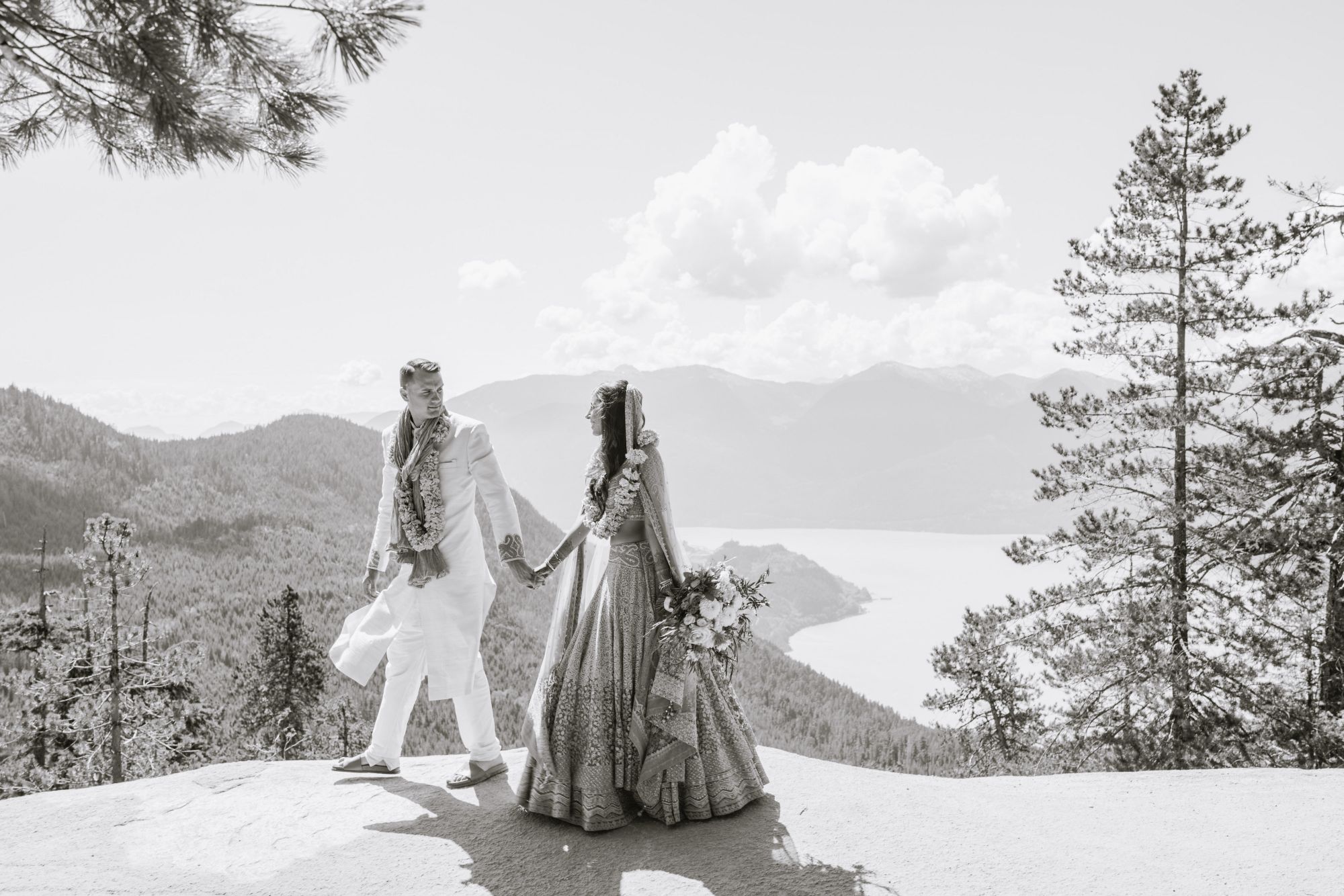 Newlywed couple in traditional dress at clifftop.