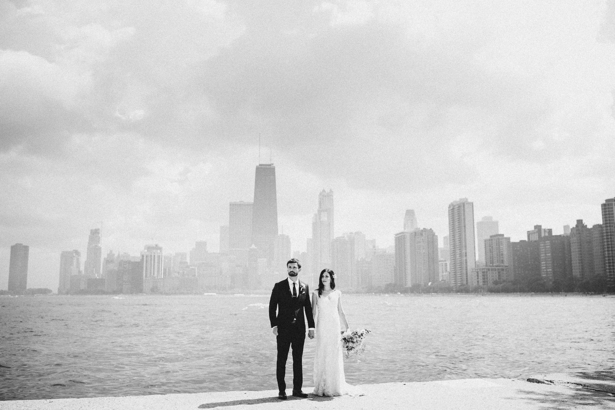 Newlywed couple with cityscape in background.