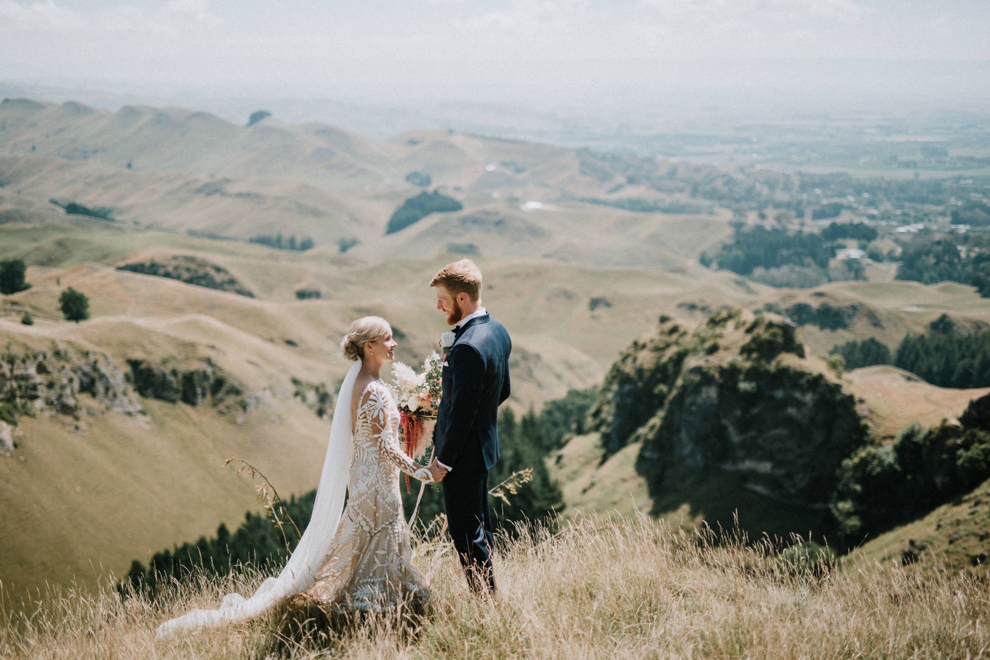Newlywed couple in atop rural hill.