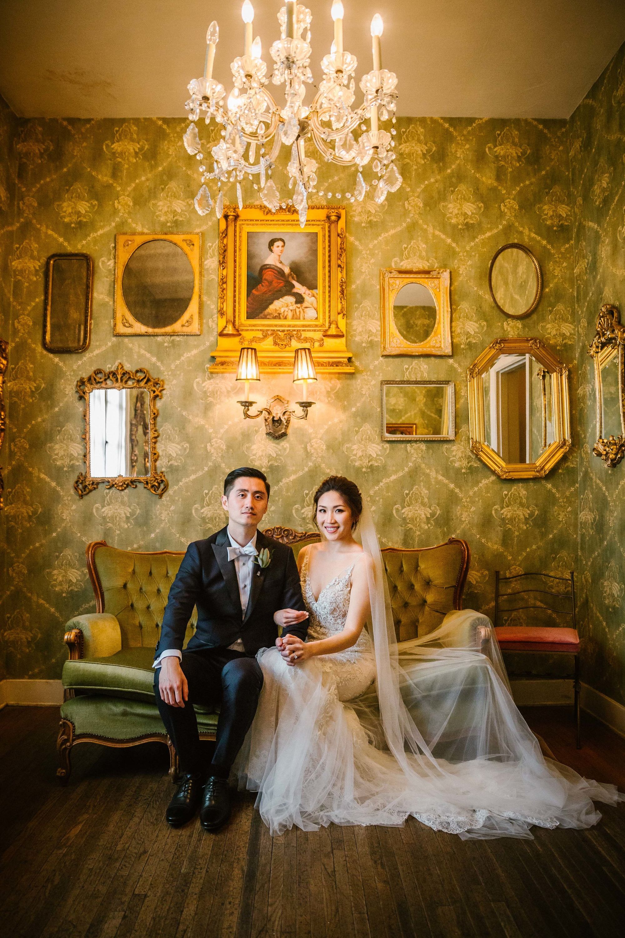 Bride and groom wedding portrait against backdrop of vintage mirrors.