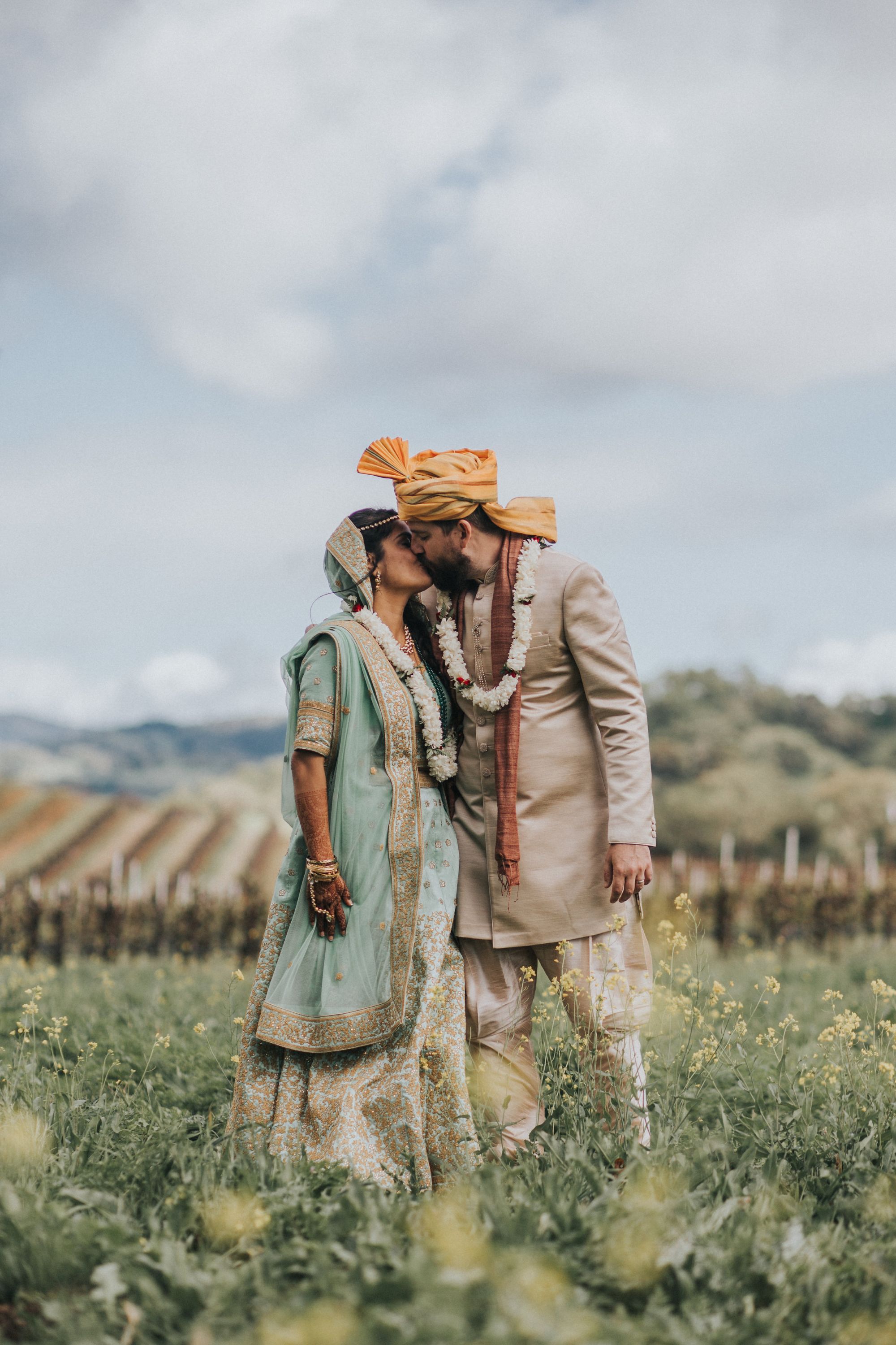 Portrait of newlywed couple in traditional dress outdoors.