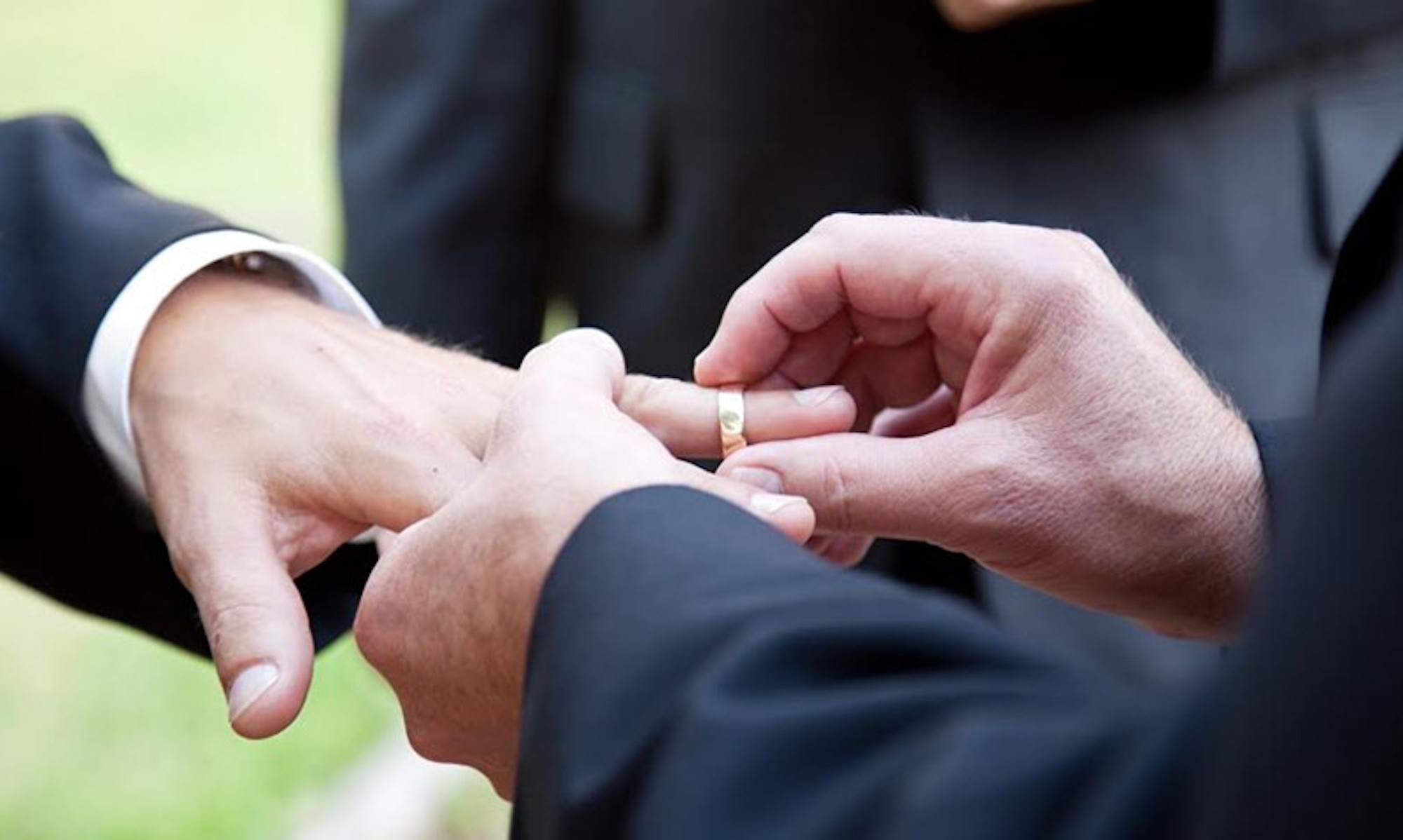 A man putting a wedding band on